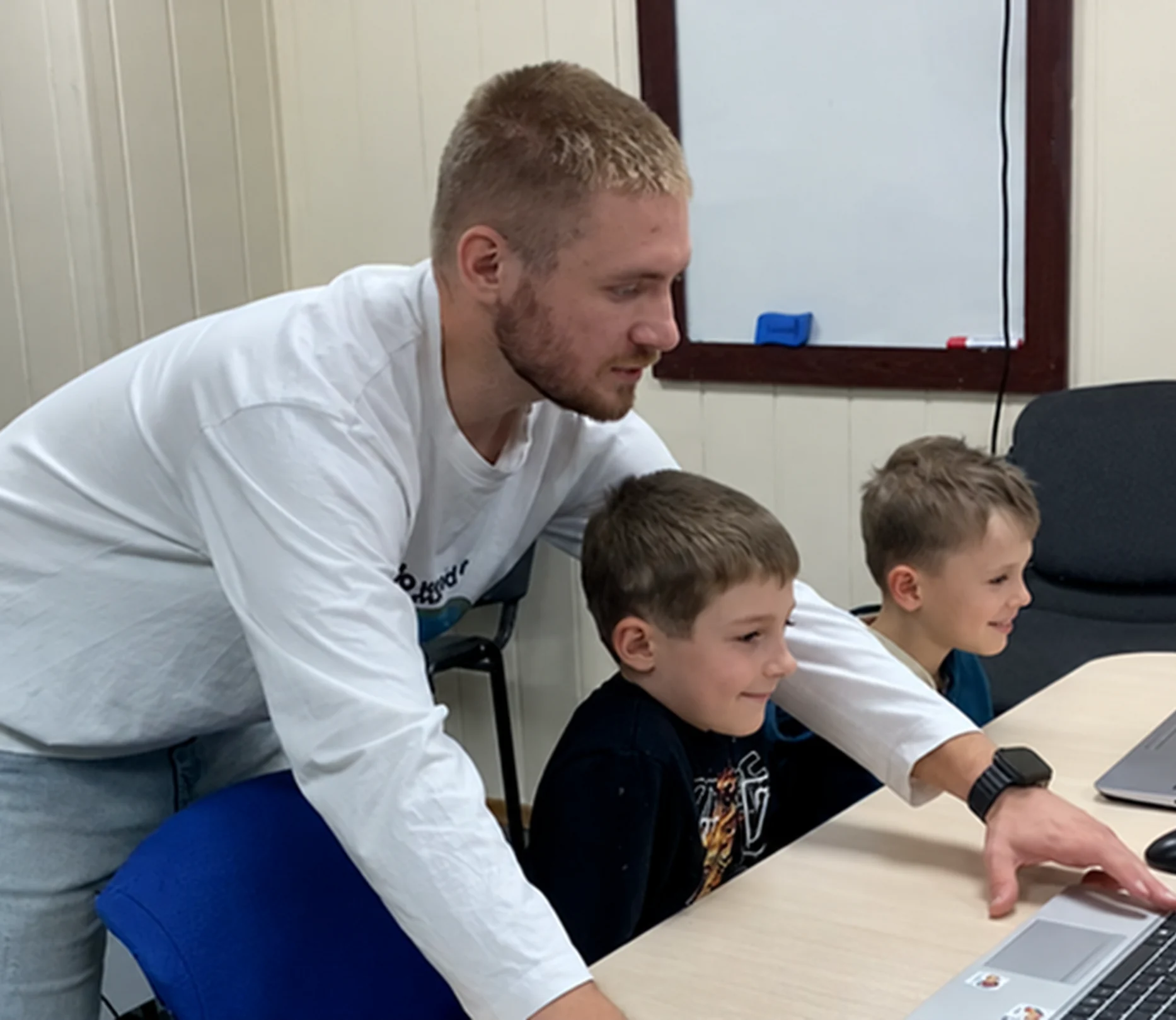 Викладач допомагає учням за ноутбуком